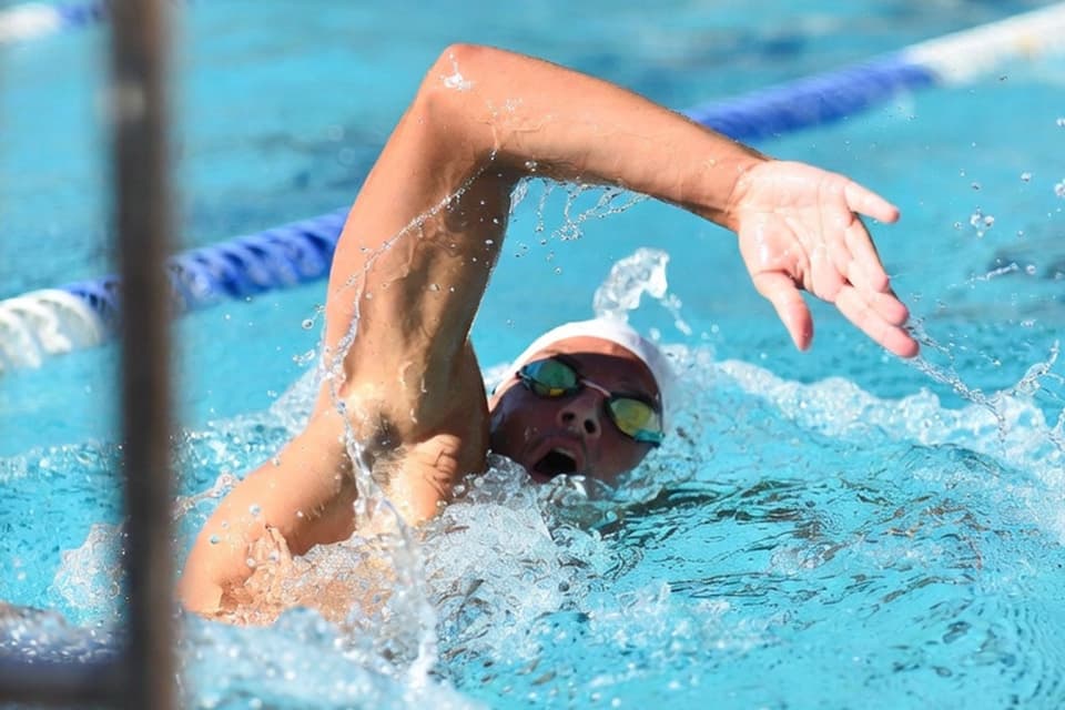 Coach reviewing data-filled split charts beside the pool